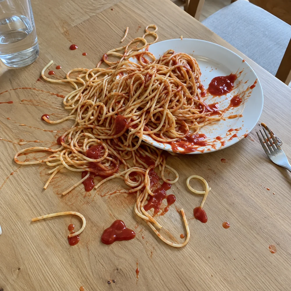 Exemple fictif : des spaghettis débordent d’une assiette et s’étalent avec du ketchup sur une table